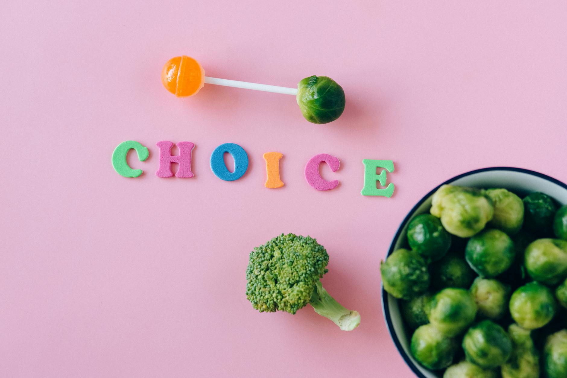 Kolorowe zdrowe i słodkie przekąski ułożone na różowym tle