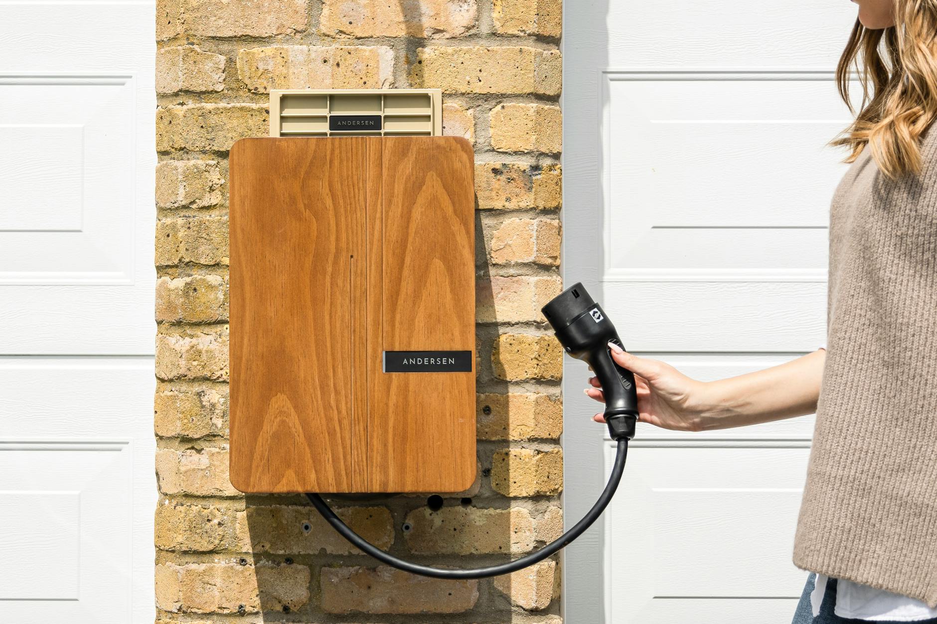 Drewniana domowa ładowarka do auta elektrycznego na ceglanej ścianie