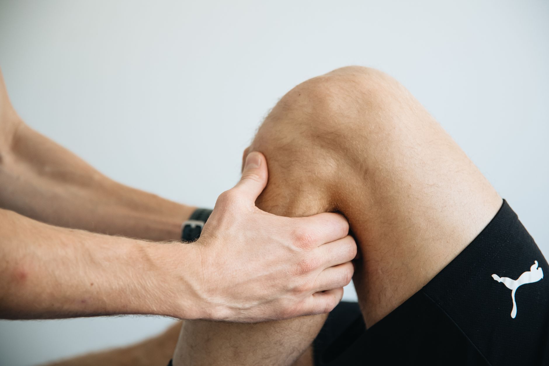 Fizjoterapeuta wykonuje masaż kolana pacjenta po rekonstrukcji ACL