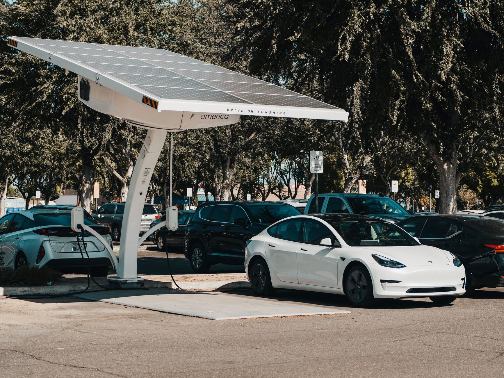 Elektryczny samochód ładujący się na zewnętrznej stacji solarnej