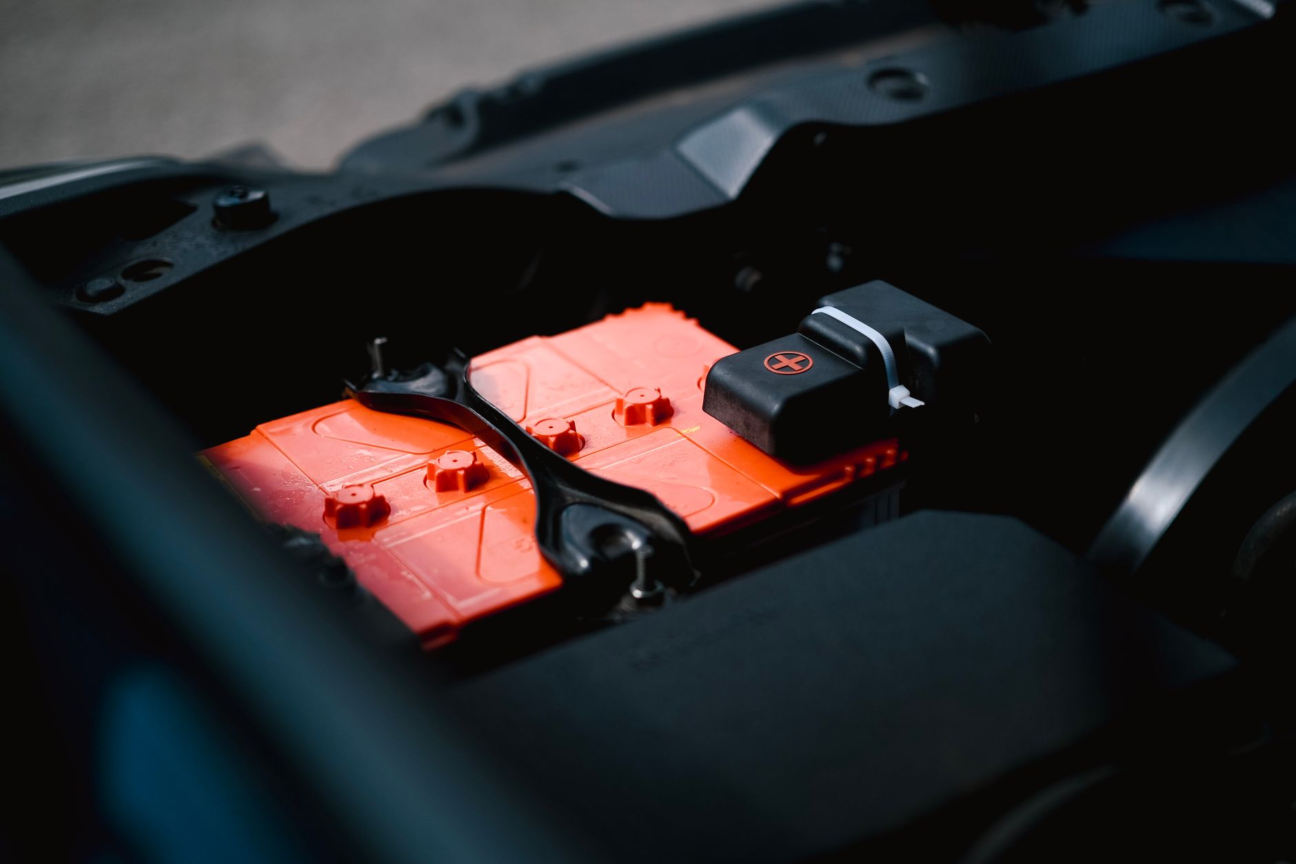 Używane auto elektryczne a degradacja baterii: jak ocenić stan magazynu energii przed zakupem Zbliżenie na pomarańczowy akumulator auta elektrycznego w komorze silnika