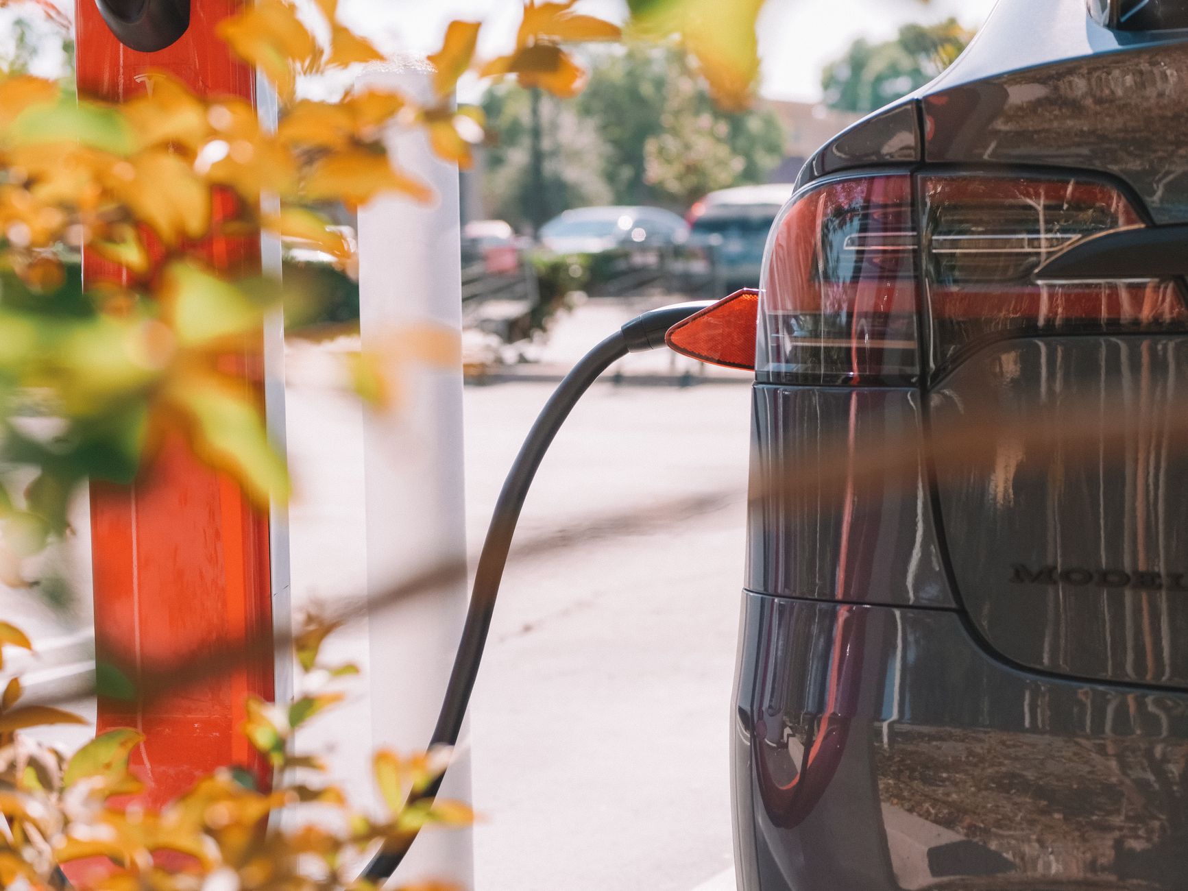 Zbliżenie na ładowanie samochodu elektrycznego przy stacji ładowania