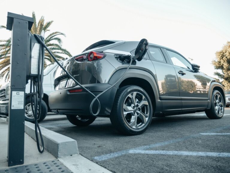 Samochód elektryczny ładowany na zewnętrznej stacji w dzień