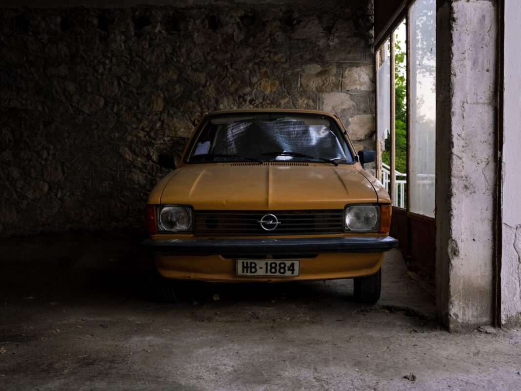 Żółty klasyczny Opel zaparkowany przy kamiennym garażu Żółty klasyczny Opel zaparkowany przy kamiennym garażu